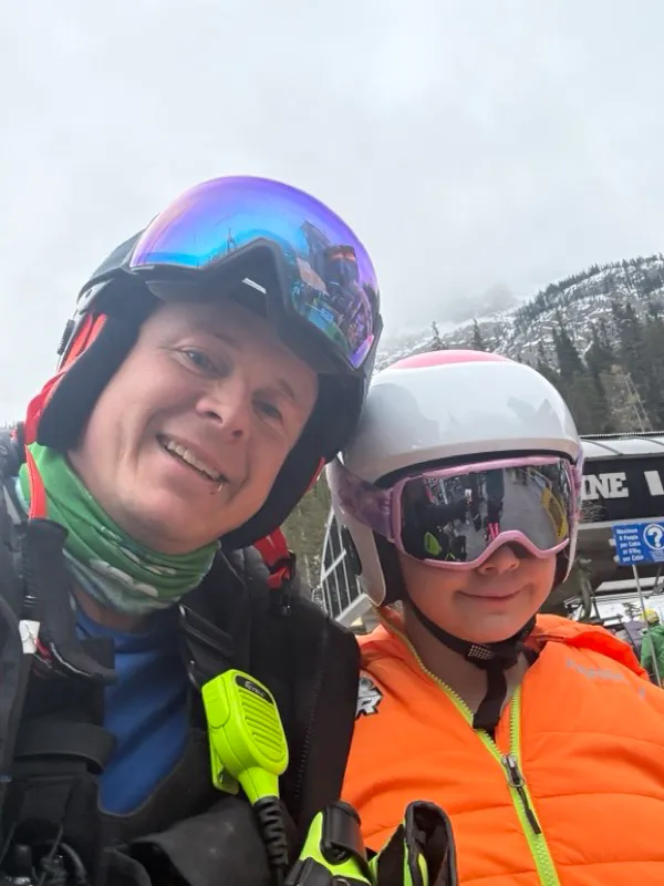 Darrin and his daughter at the hill, both in helmets and goggles